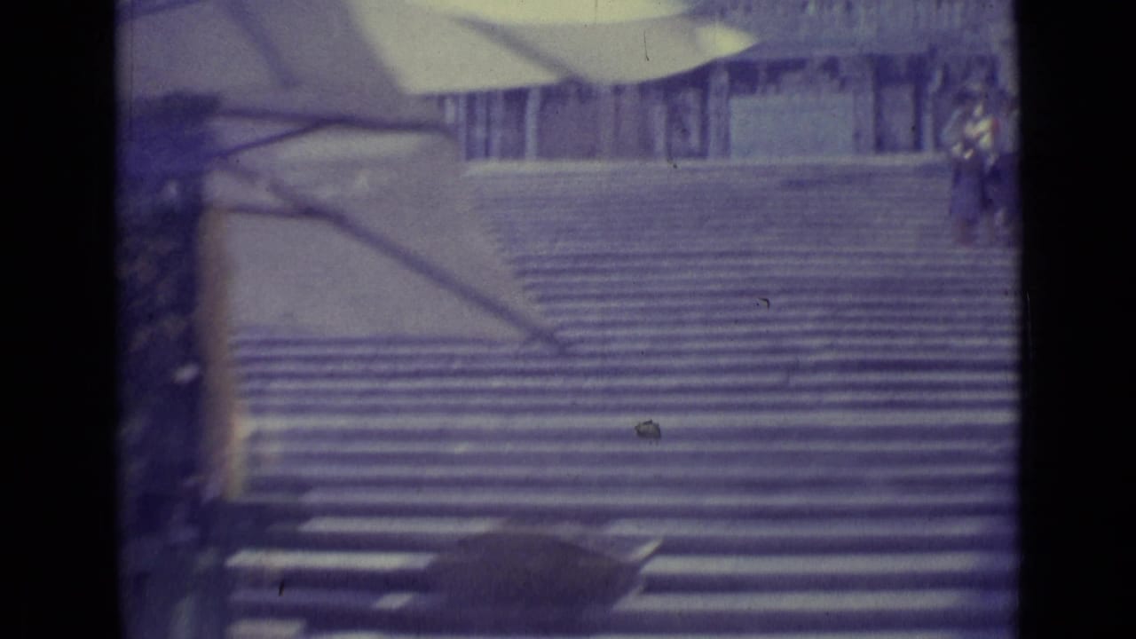 1962 Vatican City frame showing a broad staircase, partial upper canopy, and small figures near the edges of the steps.