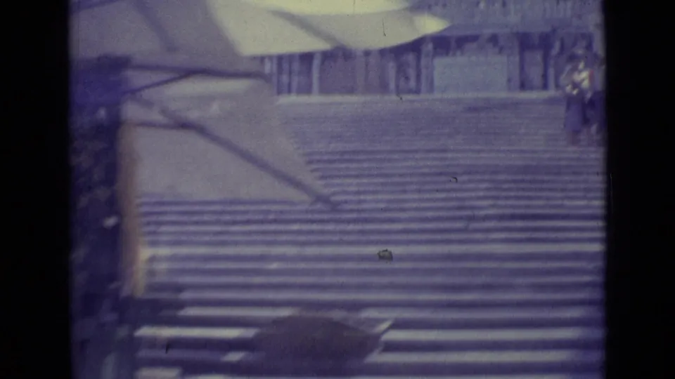 1962 Vatican City frame showing a broad staircase, partial upper canopy, and small figures near the edges of the steps.
