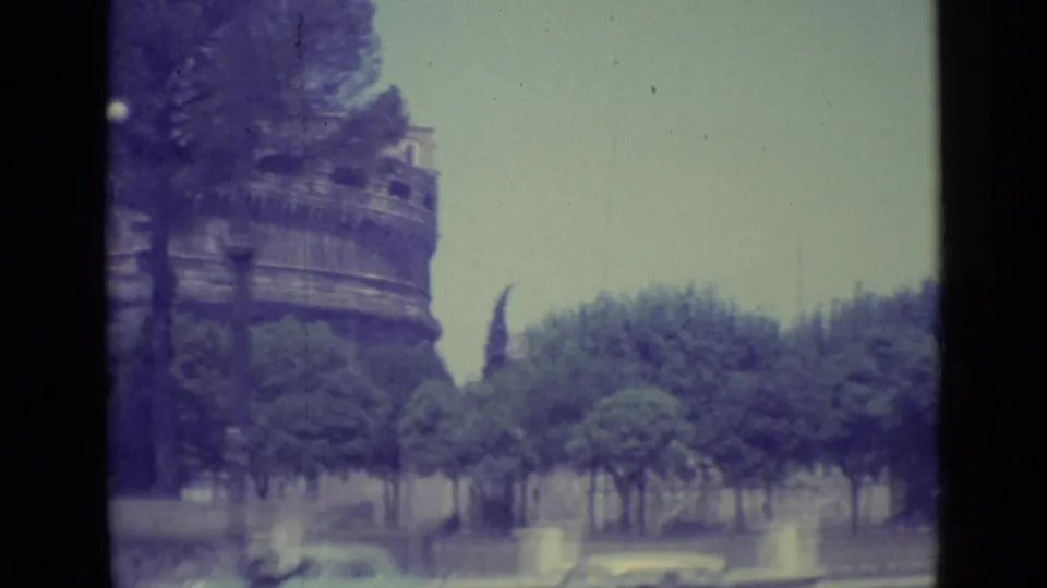 1962 8mm view near Vatican City with Castel Sant'Angelo rising behind umbrella pines and a street in the foreground.