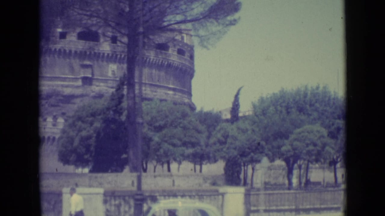 1962 Vatican City area view with Castel Sant'Angelo behind trees, a public wall, and small pedestrians near the lower frame.