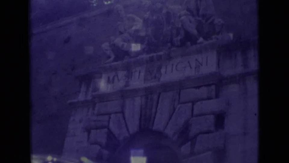 1962 8mm frame of the Musei Vaticani arched entrance in Vatican City, with carved stonework and figures above the inscription.