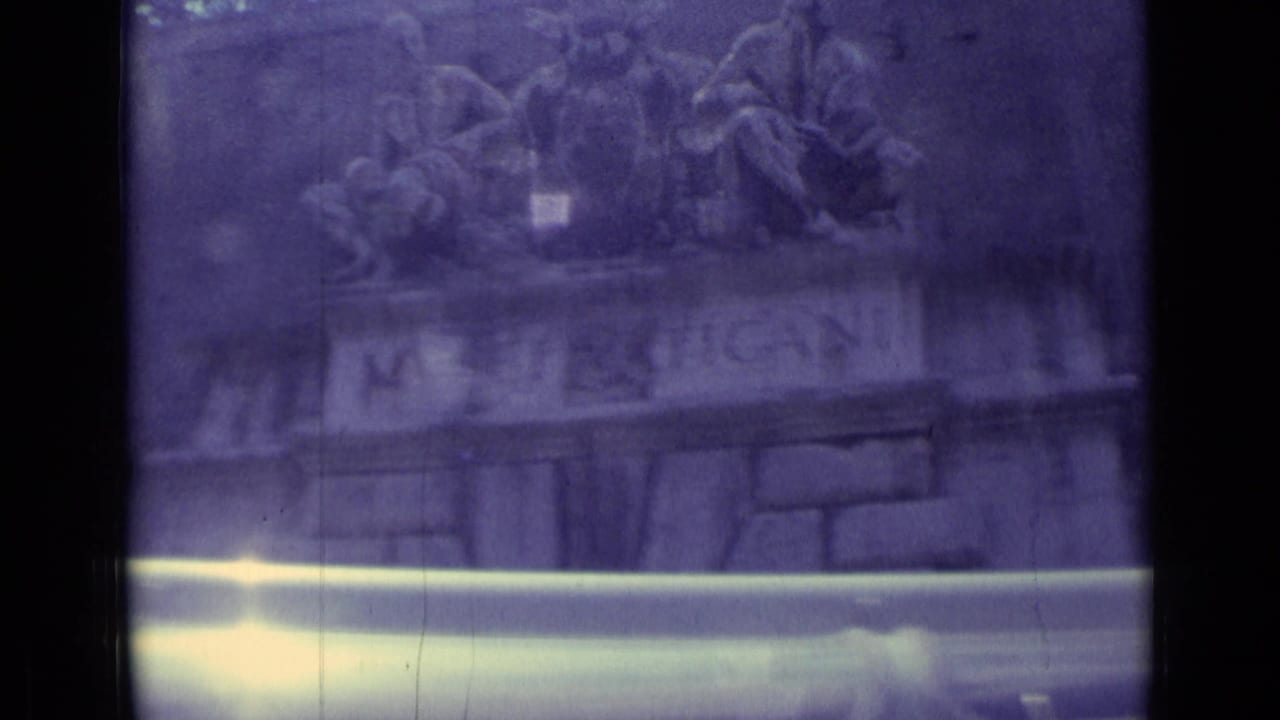 1962 8mm Vatican City footage showing the MUSEI VATICANI stone sign beneath sculpture, partly obscured by exposure flare.