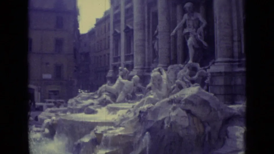 1962 Vatican City frame showing a sculptural fountain with carved figures, rocky forms, water, and tall surrounding architecture.