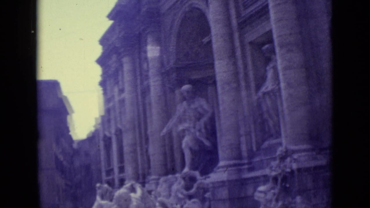 1962 8mm travel frame showing Trevi Fountain statues and columns from a tilted handheld angle.