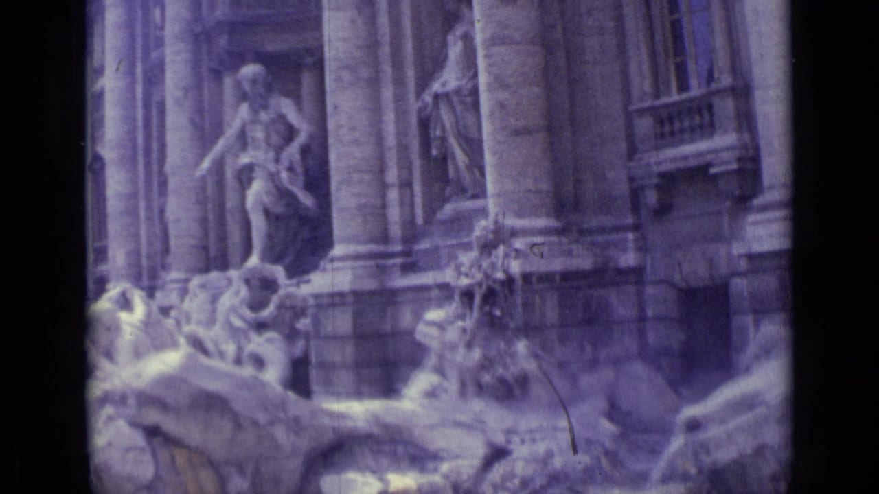 Stone fountain sculptures and columns seen in soft handheld 8mm footage.
