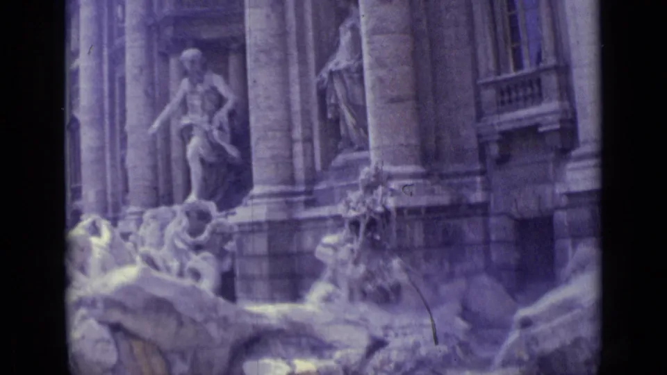 1962 8mm travel frame showing sculpted fountain figures, rockwork, and tall architectural columns at the Trevi Fountain.