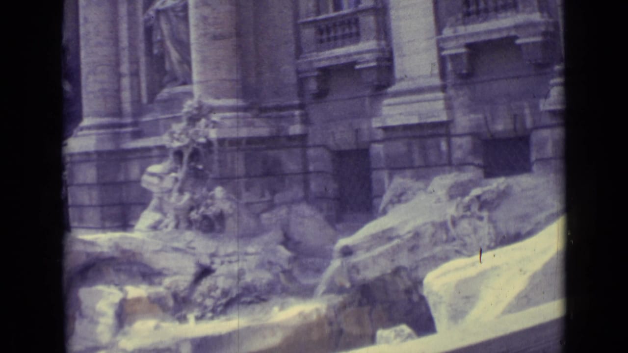 Aged 8mm frame of Trevi Fountain stonework and statuary, with a dark vertical strip from the contact-sheet layout.