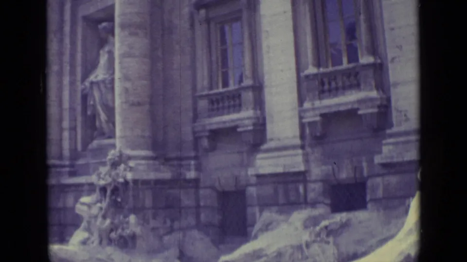 1962 home-movie view of tall columns, windows, and partial Trevi Fountain sculpture with visible grain and color shift.