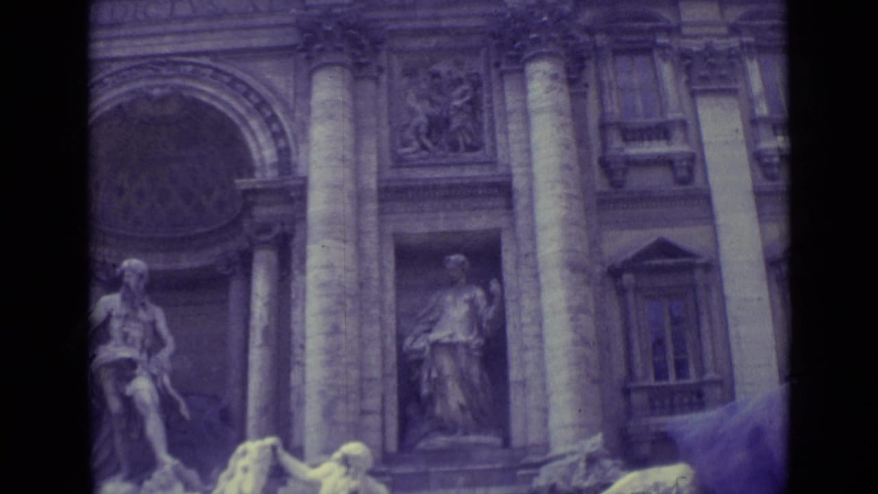 1962 Vatican City home-movie frame showing a monumental stone facade with columns, sculptural niches, and arched architectural details.