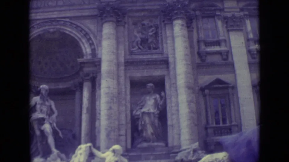 1962 Vatican City home-movie frame showing a monumental stone facade with columns, sculptural niches, and arched architectural details.