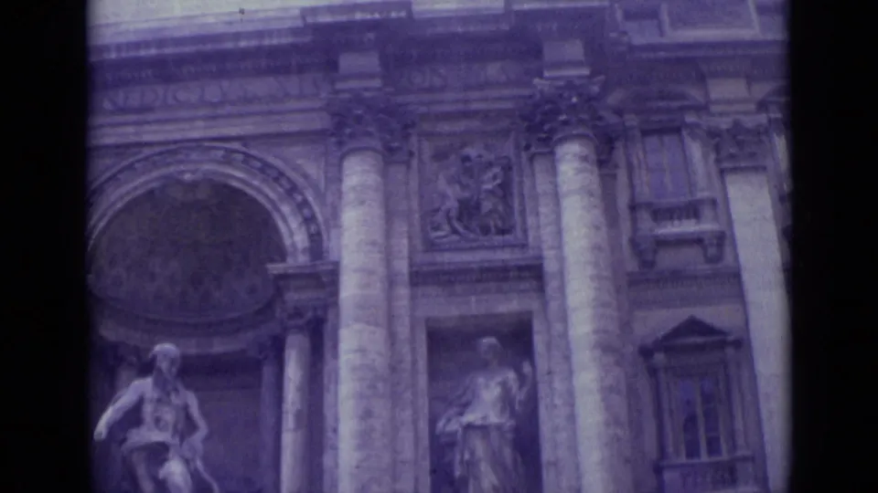 1962 Vatican City frame of a monumental facade, with columns, an arched recess, sculptural figures, and aged purple-blue film tint.