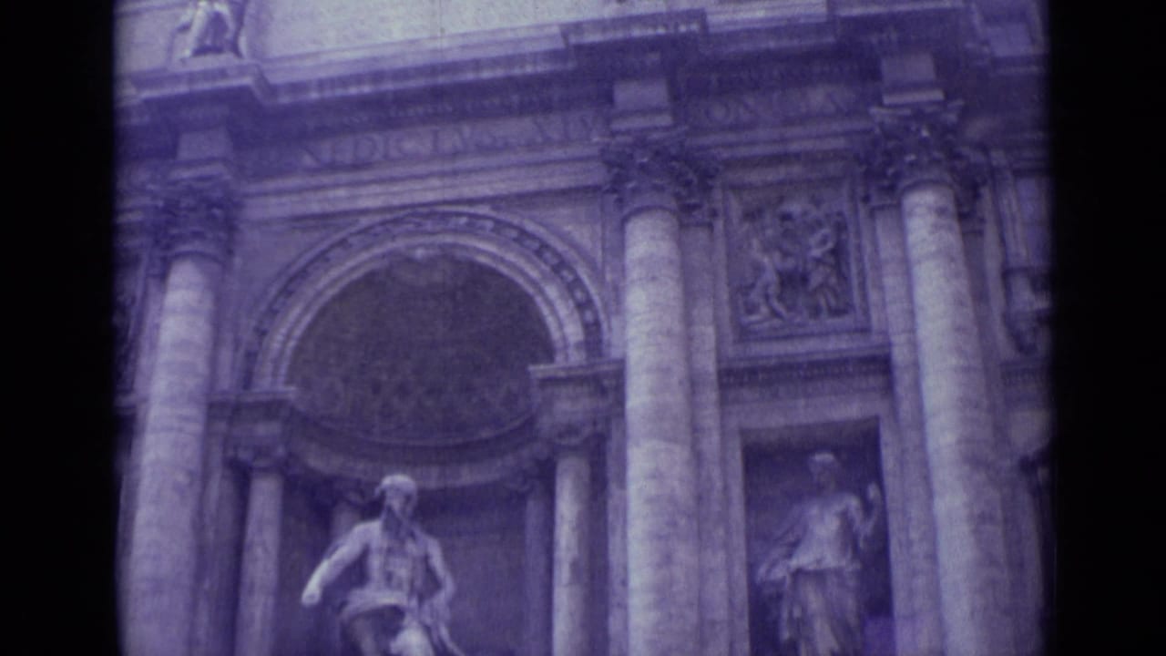 Upper Trevi Fountain facade with columns, arched niche, and stone figure.