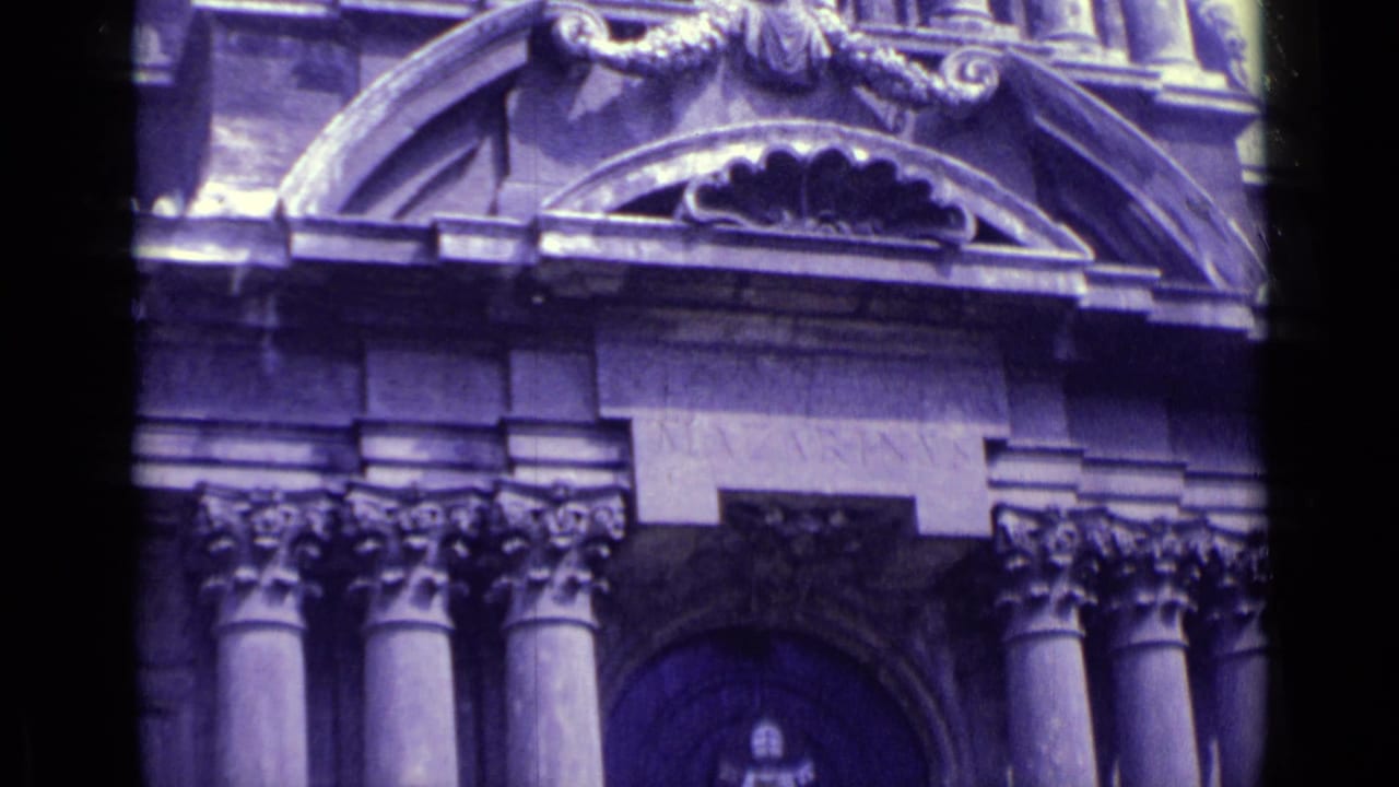 1962 Vatican City home-movie frame showing an ornate institutional facade with arched stonework, columns, and a dark entrance.