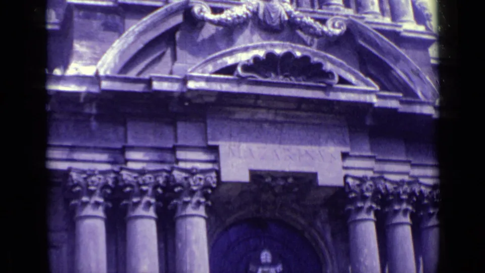 1962 Vatican City home-movie frame showing an ornate institutional facade with arched stonework, columns, and a dark entrance.