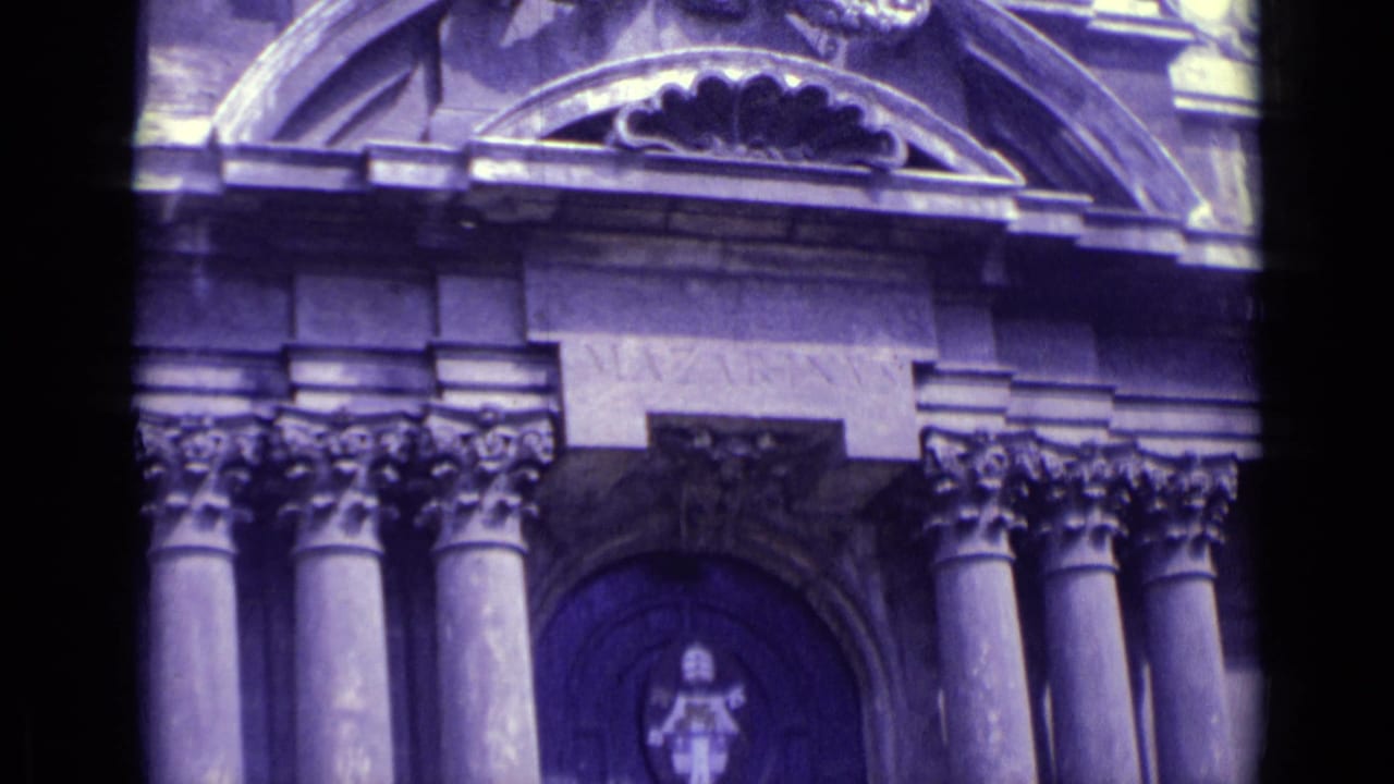 Vatican City architectural facade in 8mm footage, with repeated arches, column capitals, and a shield-like emblem on the doorway.