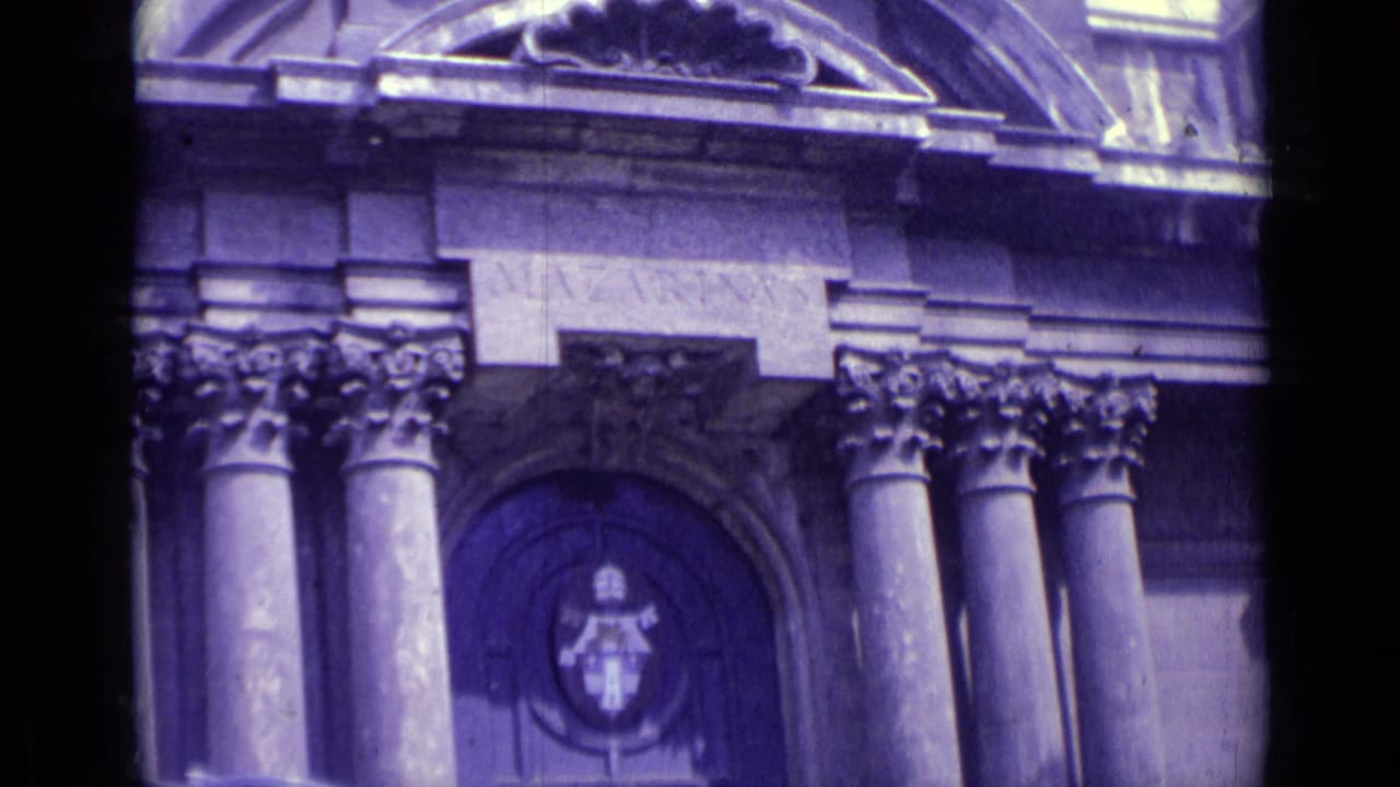 Handheld 8mm view of the same Vatican City institutional entrance, emphasizing columns, carved stonework, and the central doorway emblem.