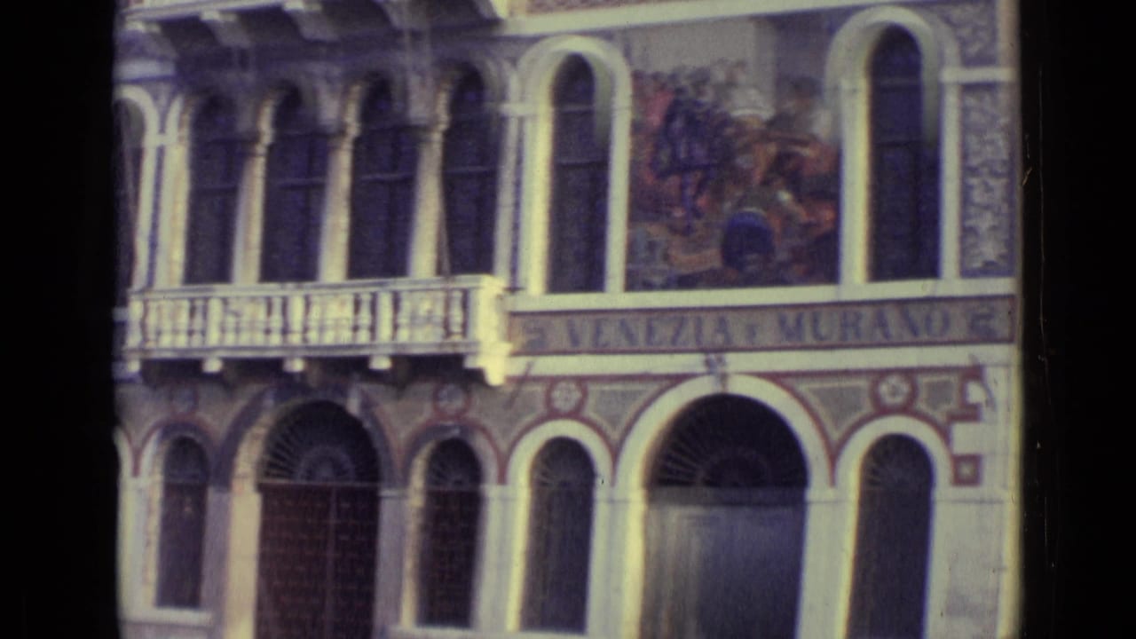 Ornate Venetian facade with arched windows, balcony, mural panel, and Venezia e Murano sign.
