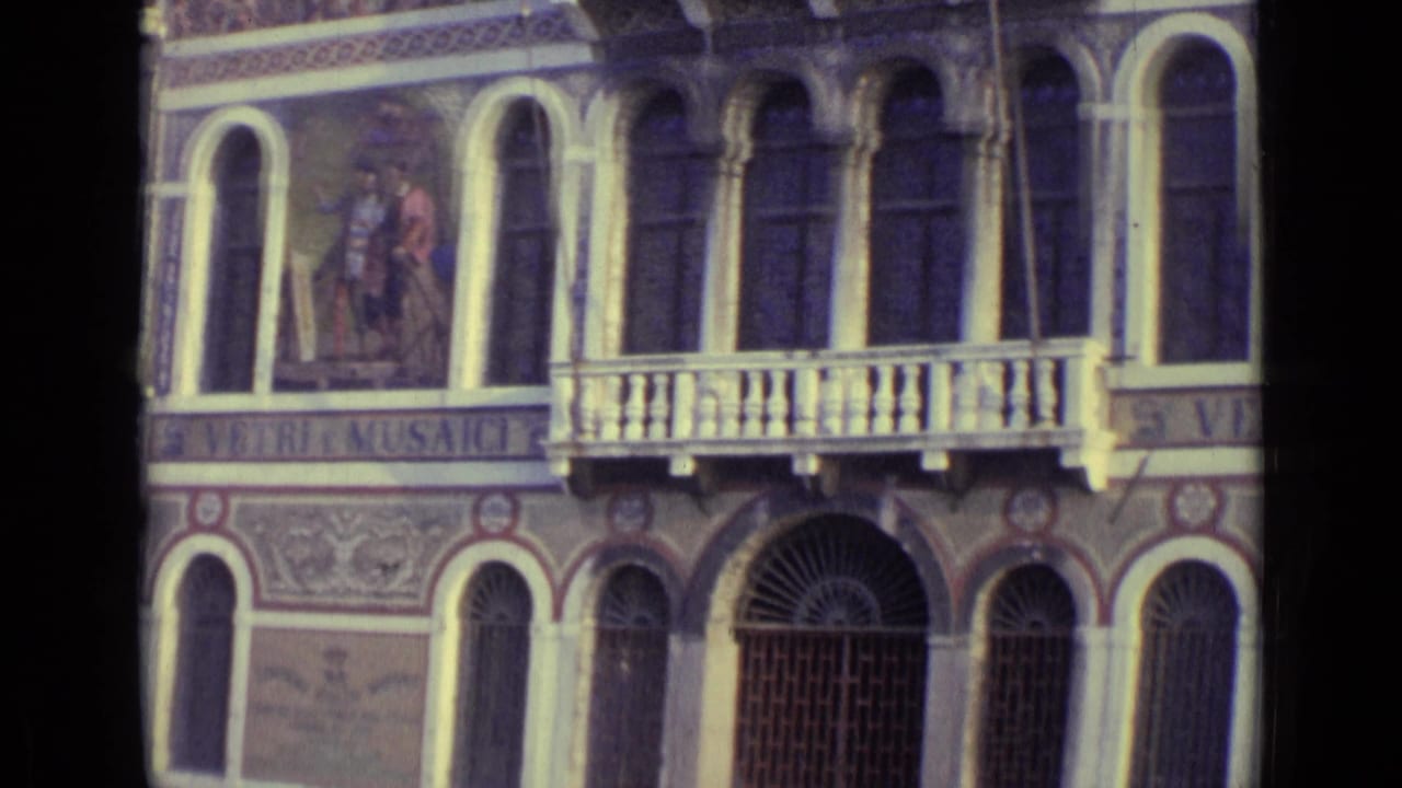 1962 Venice frame with a decorative building facade, arched windows, balcony rail, painted figure panel, barred doorway, and partial Murano lettering.