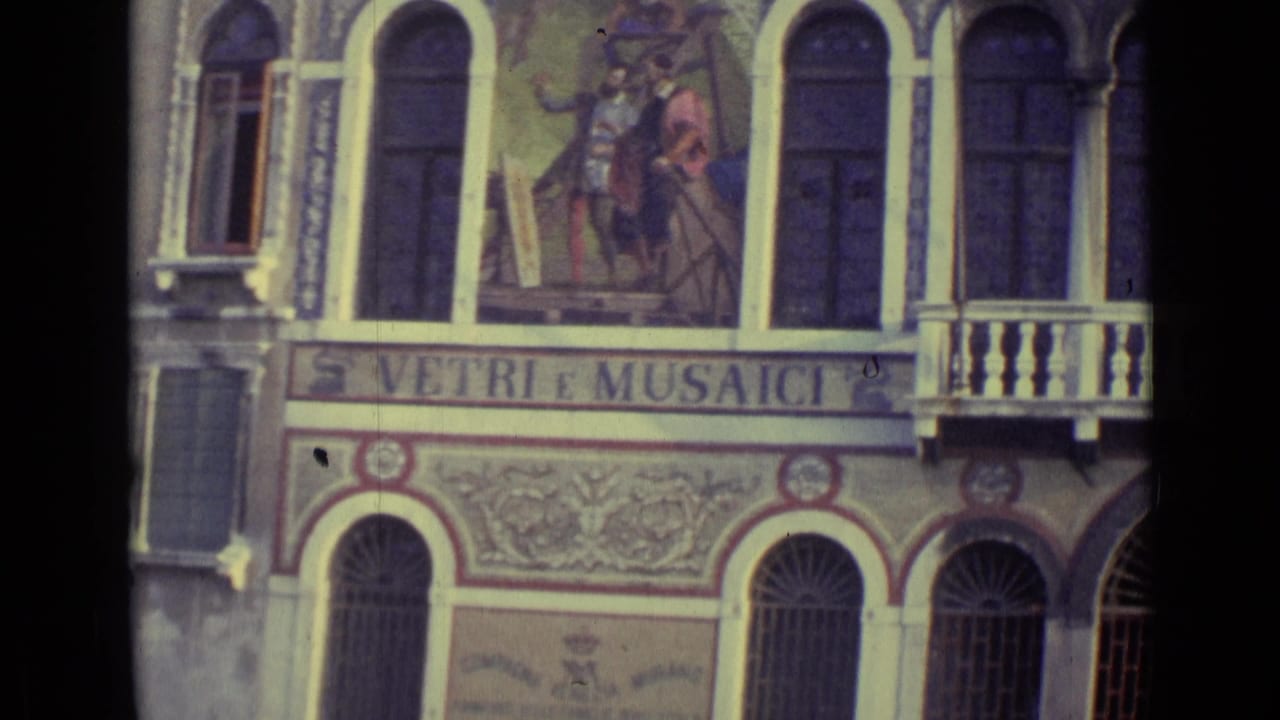 1962 Venice 8mm frame showing a decorated canal-side facade with arched windows, a balcony, and VETRI E MUSAICI lettering.