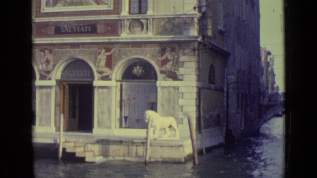 1962 Venice 8mm frame of the SALVIATI canal entrance with arched doors, water steps, and a white lion statue near the canal.