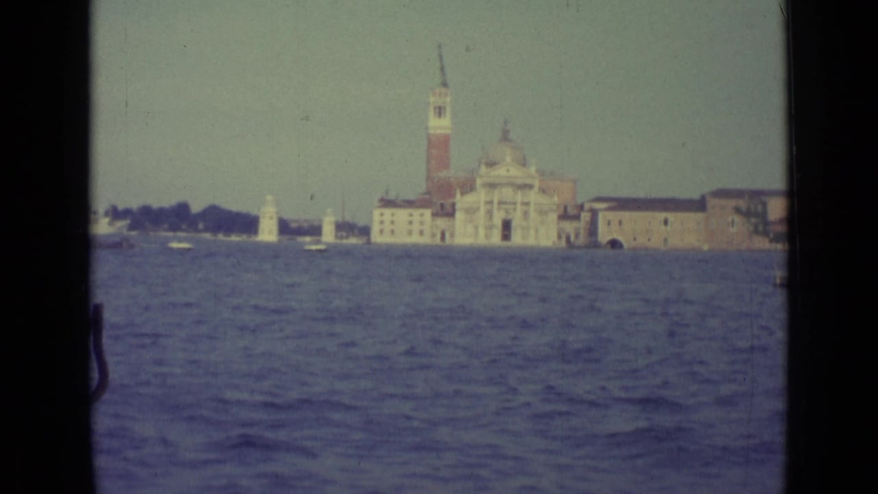Venice lagoon view with San Giorgio Maggiore across the water and dark boat-window edges.