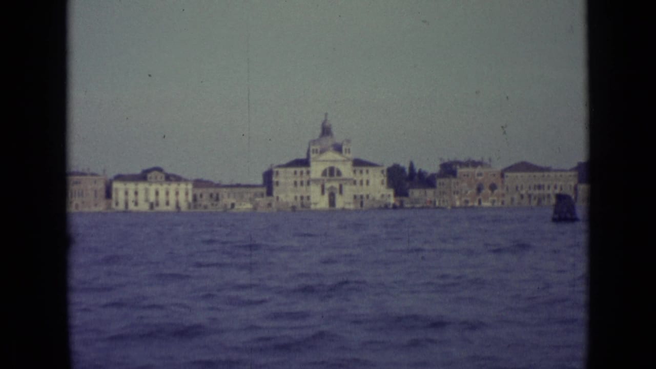 Venetian waterfront with domed building, low historic structures, and open water in the foreground.