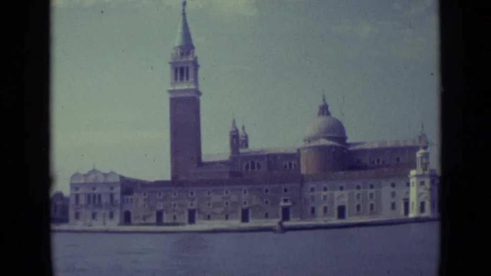 1962 Venice frame of San Giorgio Maggiore with its tall bell tower, domed church roof, facade, shoreline, and canal water.