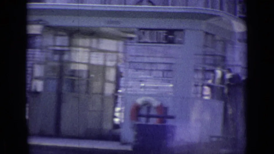 1962 Venice frame of a public facade with railings, doorways, windows, and a red hydrant-like object in the foreground.