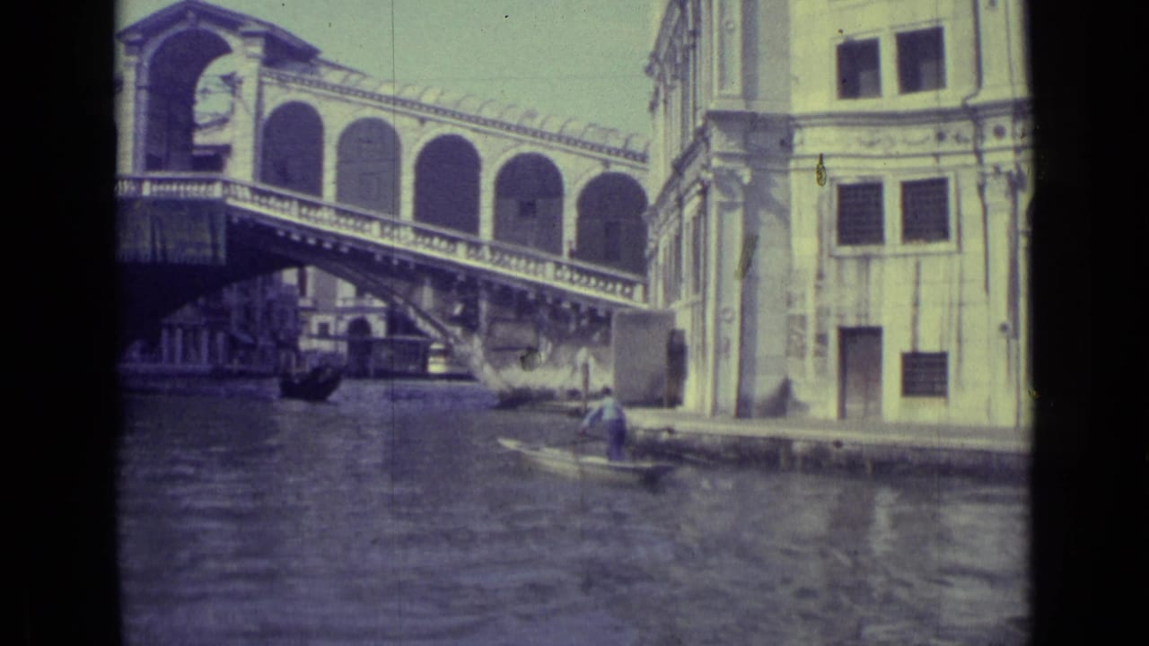 Rialto Bridge over a Venice canal with a gondolier near the waterline.