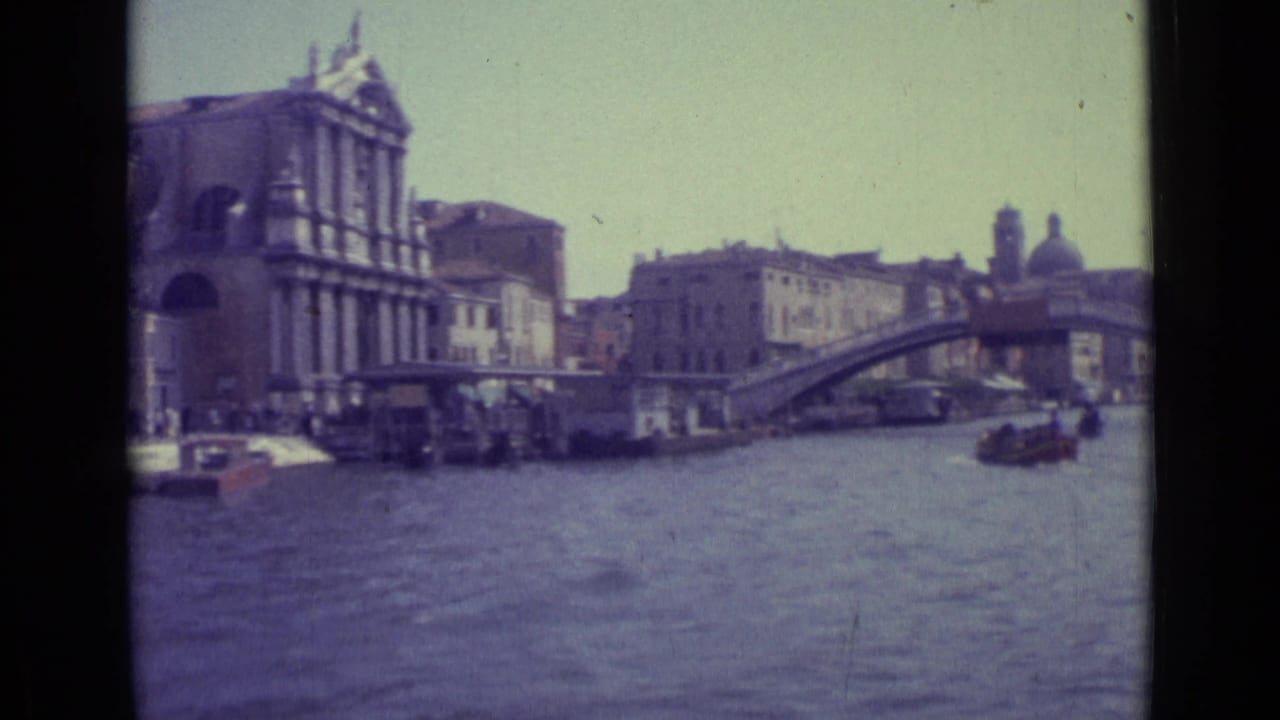 Rialto Bridge and Grand Canal with Venetian buildings and small boats.