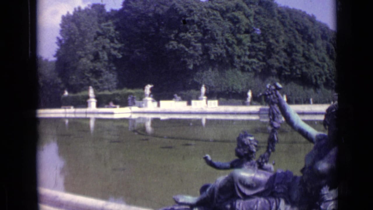Formal pool at Versailles with statues, trees, reflections, and a bronze fountain sculpture in the foreground.