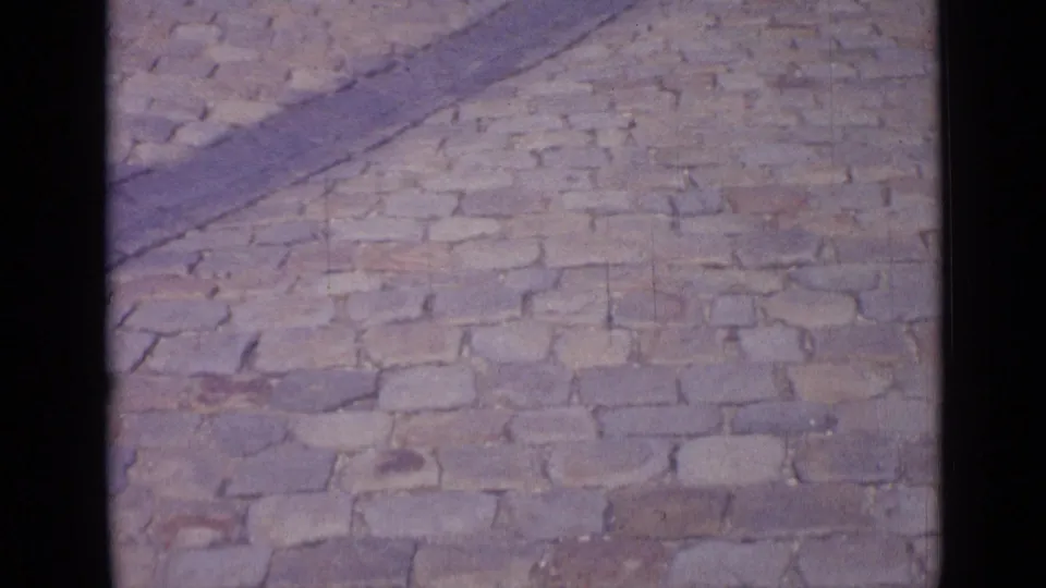 1962 Versailles frame of cobblestone paving, soft focus, and visible 8mm frame borders after the fountain view.