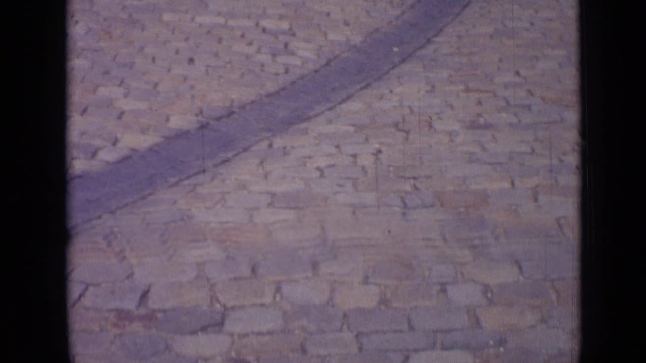 Cobblestone square with a curved stone border crossing the frame.