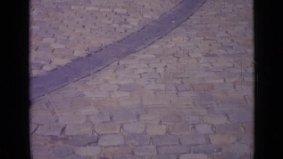 1962 Versailles footage showing a close view of cobblestone paving and a curved stone border in a public square.