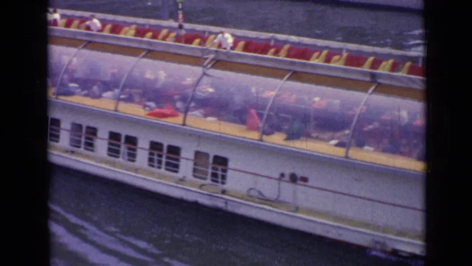 The 8mm frame shows a white Versailles tourist boat from above, with passengers seated under the canopy.