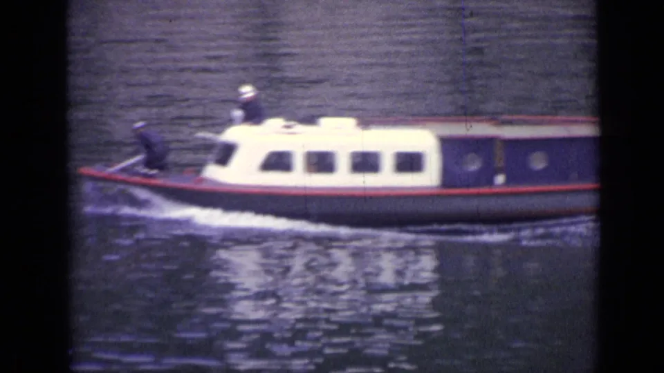 A closer 8mm view shows the boat’s bow and cabin sliding across the water in Versailles.