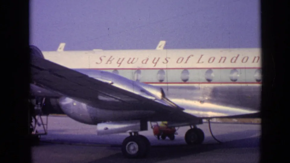 A Skyways of London aircraft appears on a tarmac, with the wing, landing gear, and branded fuselage visible in 8mm color.