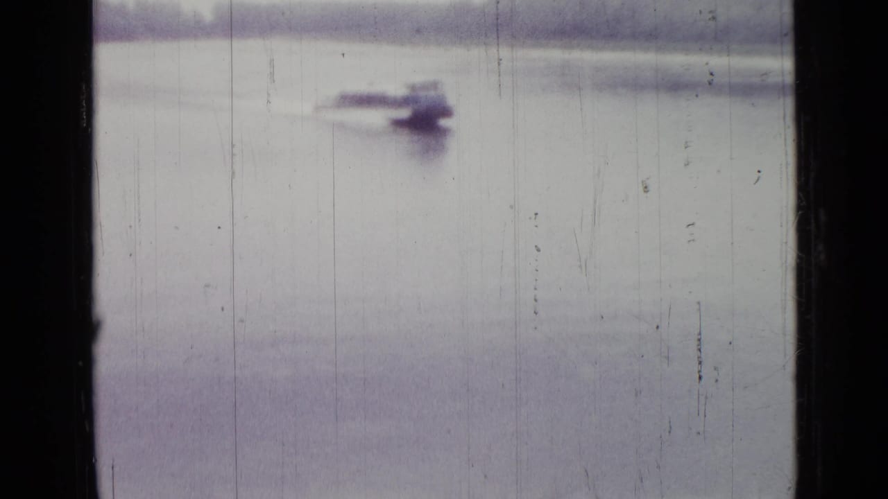 Small motorboat crossing pale water near the top of the frame.