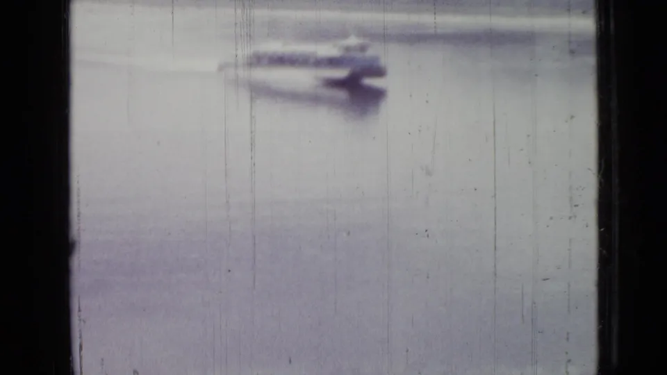The motorboat is closer and more motion-blurred, leaving a visible wake across the pale water surface.