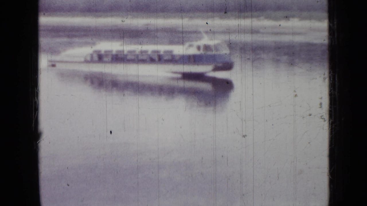 The white-and-blue boat continues across the water in the 1967 Saint Petersburg footage, with soft focus and pale reflection visible.
