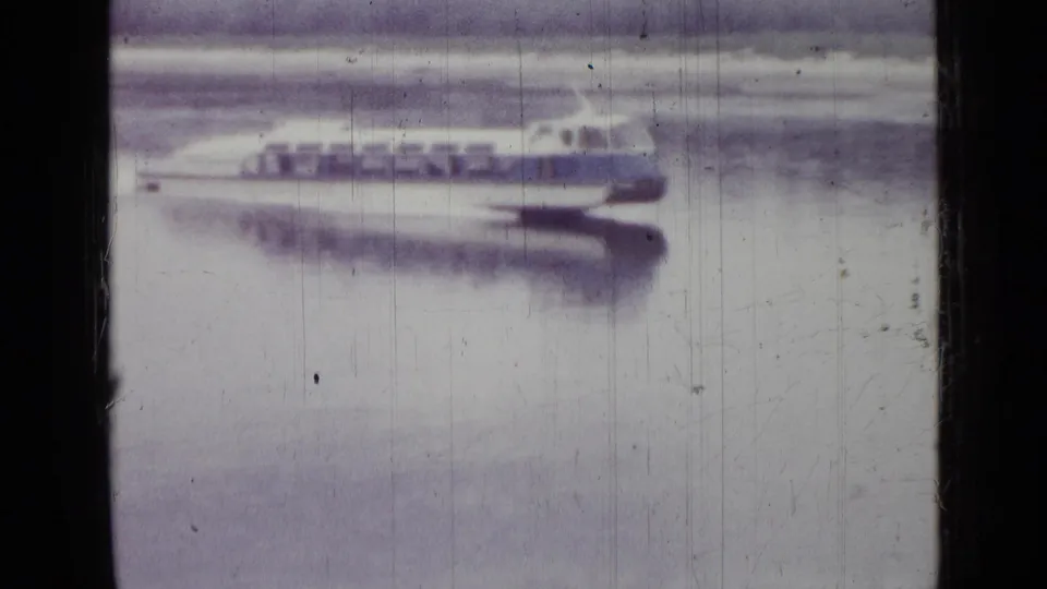 The white-and-blue boat continues across the water in the 1967 Saint Petersburg footage, with soft focus and pale reflection visible.