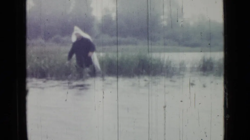 The wading figure appears closer, leaning or stepping through water among reeds in the Saint Petersburg marsh scene.