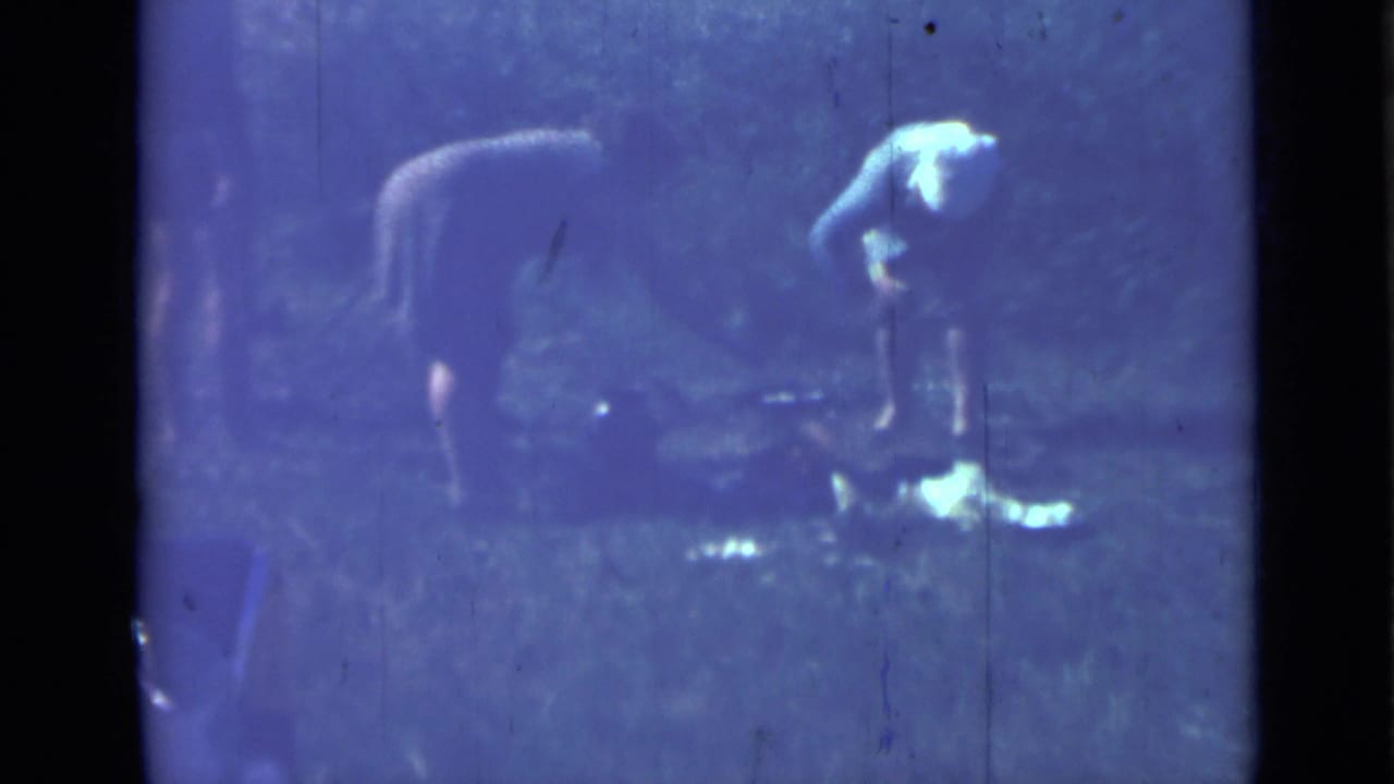 The 8mm frame shows two women at an outdoor meal preparation spot in Saint Petersburg, Russia, with soft focus and blue-tinted film wear.