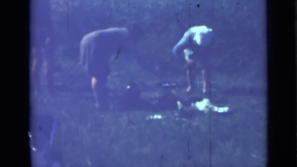 The 8mm frame shows two women at an outdoor meal preparation spot in Saint Petersburg, Russia, with soft focus and blue-tinted film wear.