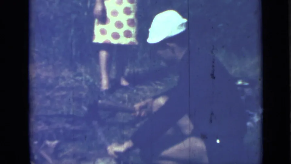 The woman bends near the foreground as another person in a similar polka dot dress stands partly visible behind her.