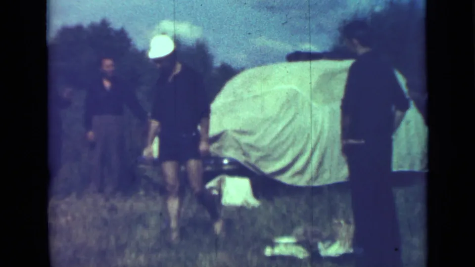 The final frame shows adults in a grassy Saint Petersburg campsite scene, with one figure in a white hat beside the covered vehicle.