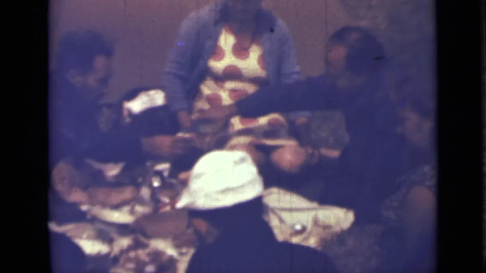 1967 Saint Petersburg home-movie frame of adults eating and talking around a table in a private interior.