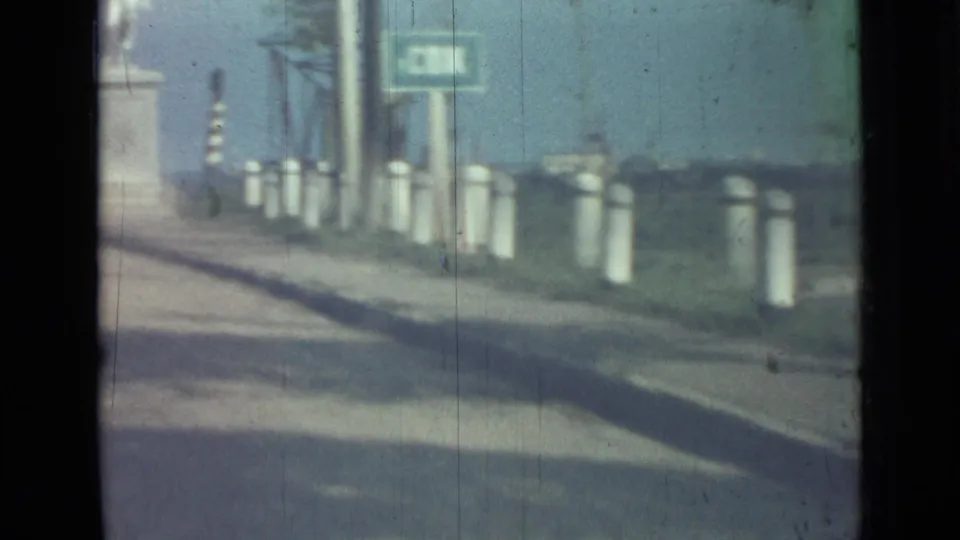 A 1967 Saint Petersburg roadside scene shows white posts, utility poles, a green sign, and open ground beyond the road.