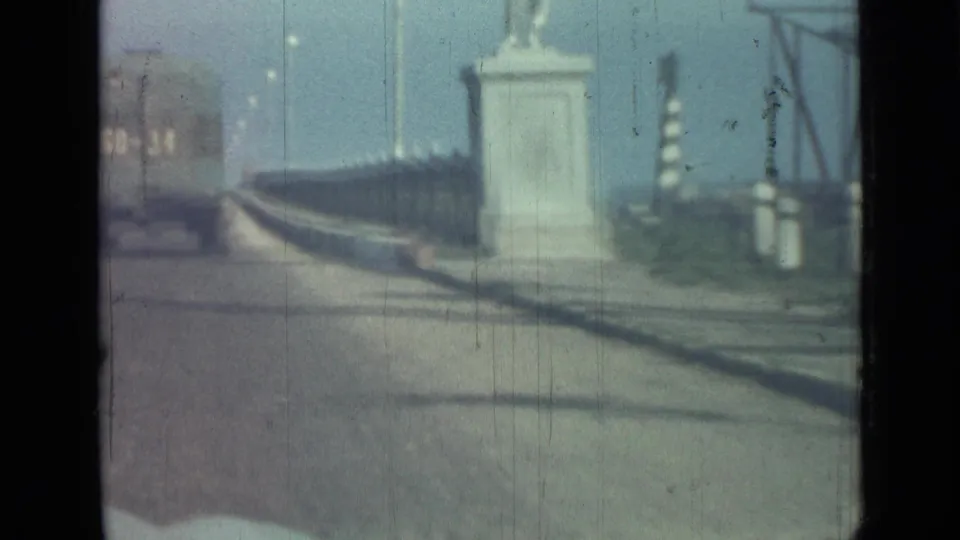 A moving 8mm view in Saint Petersburg shows a distant truck, roadside posts, and a dark railing along the edge of the road.