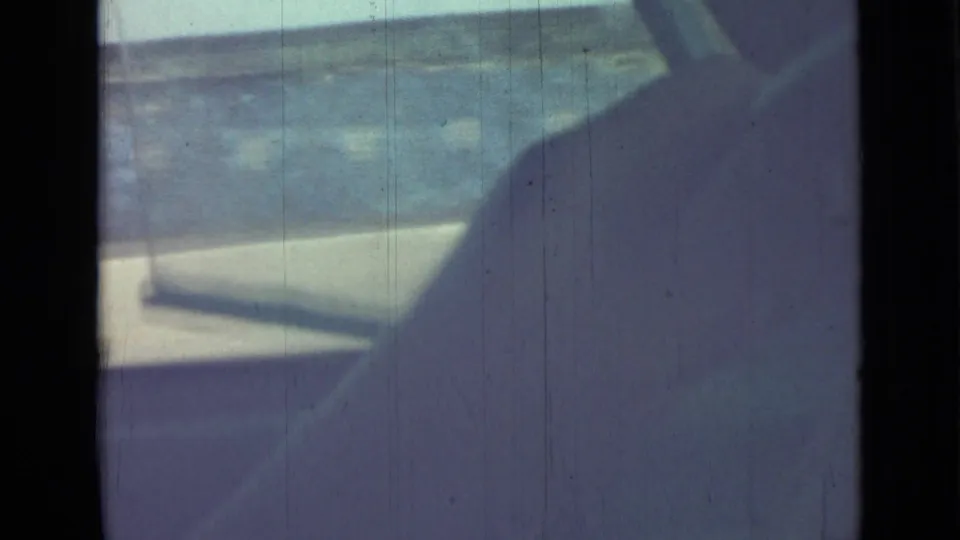 A low, handheld 8mm view from a moving car shows pavement, roadside blur, and interior shadow in Saint Petersburg metadata context.